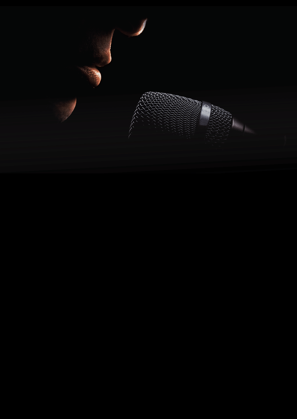 Part of a singer face, details of mouth and modern black microphone, on black background  